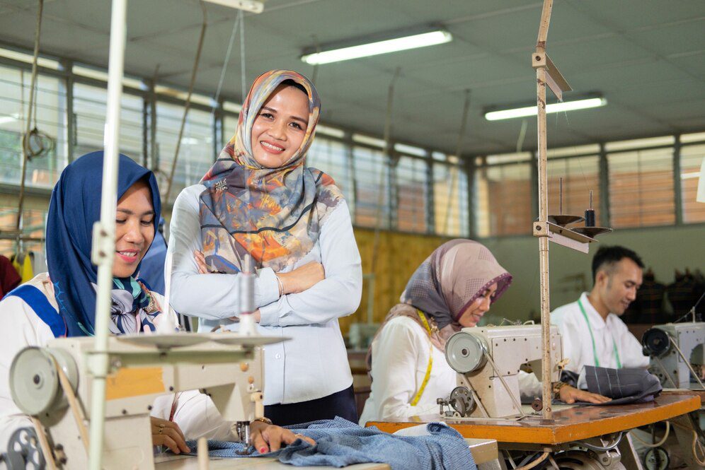 female-supervisor-headscarf-smiling-crossed-hands-stands-side-seamstress-using_8595-25145